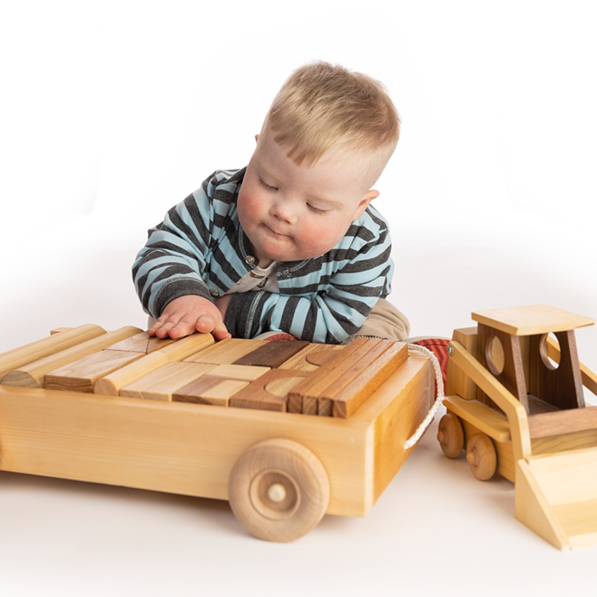 Toddler with Down syndrome playing with wooden toys