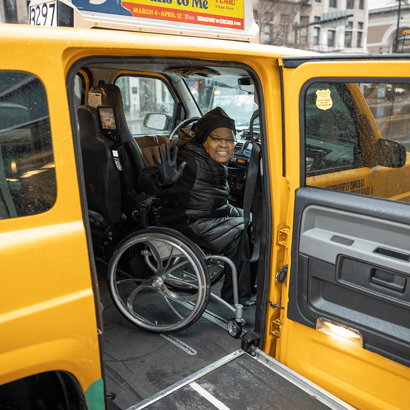 Wheelchair user exiting accessible taxi