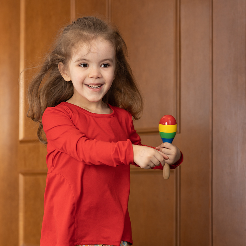Young girl with Autism holding toy and smiling