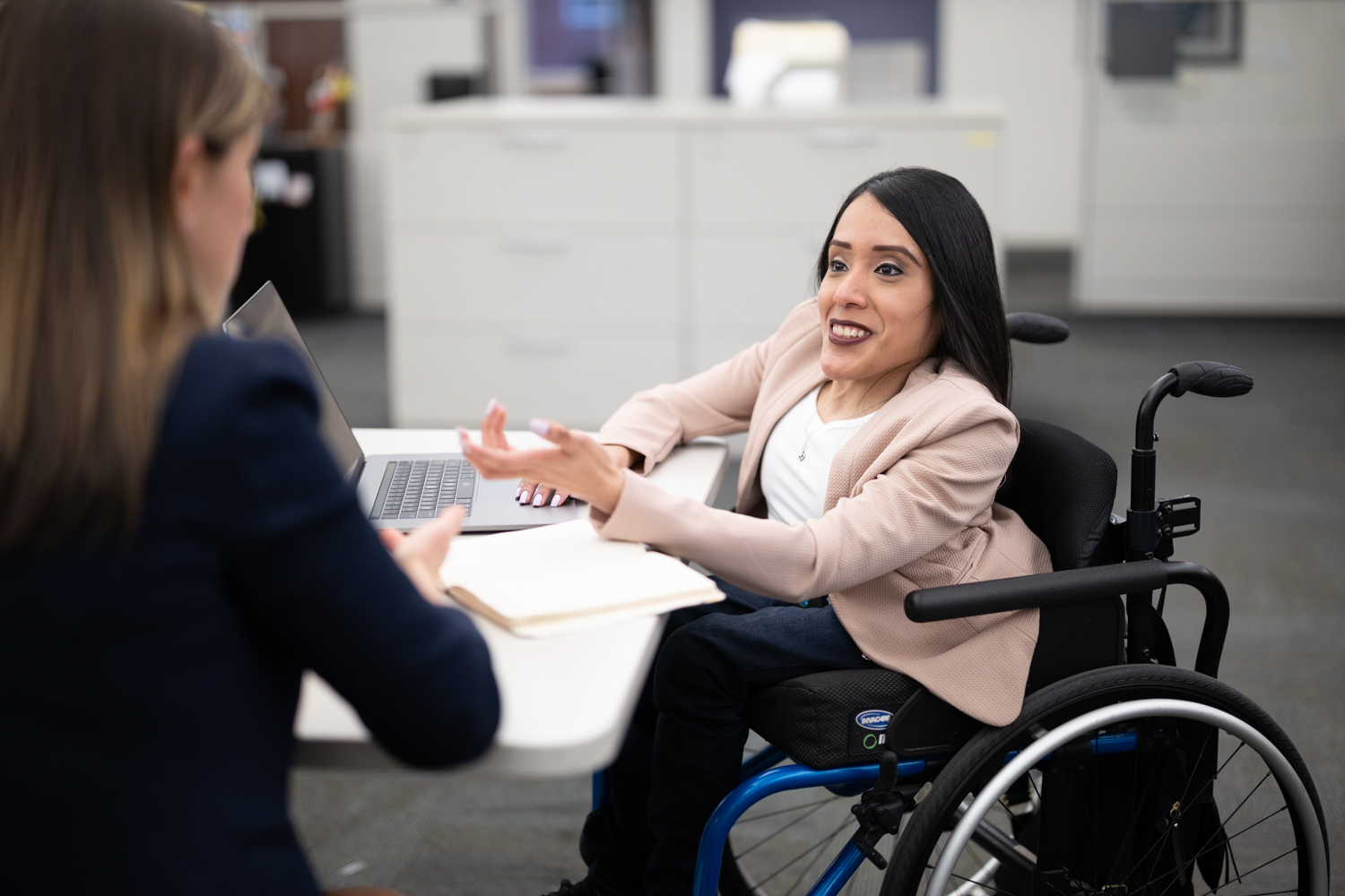 Woman wheelchair user having office meeting with colleague